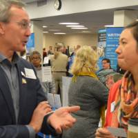 Two alumni talk to one another at the Academic Major Fair.